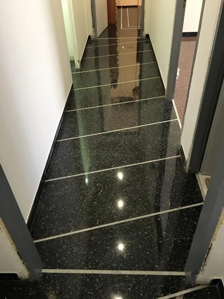 Black terrazzo corridor with strip inlays after grinding and polishing