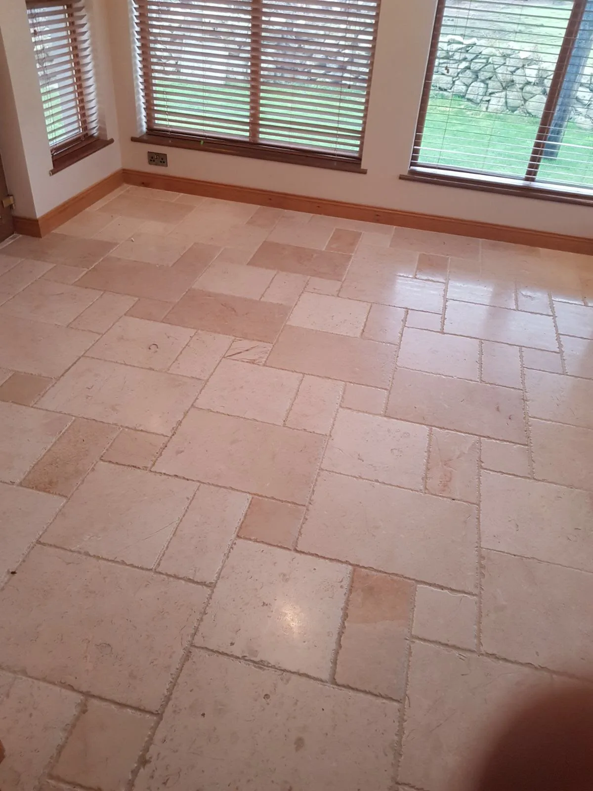 Tumbled limestone living room floor after cleaning, honing and sealing