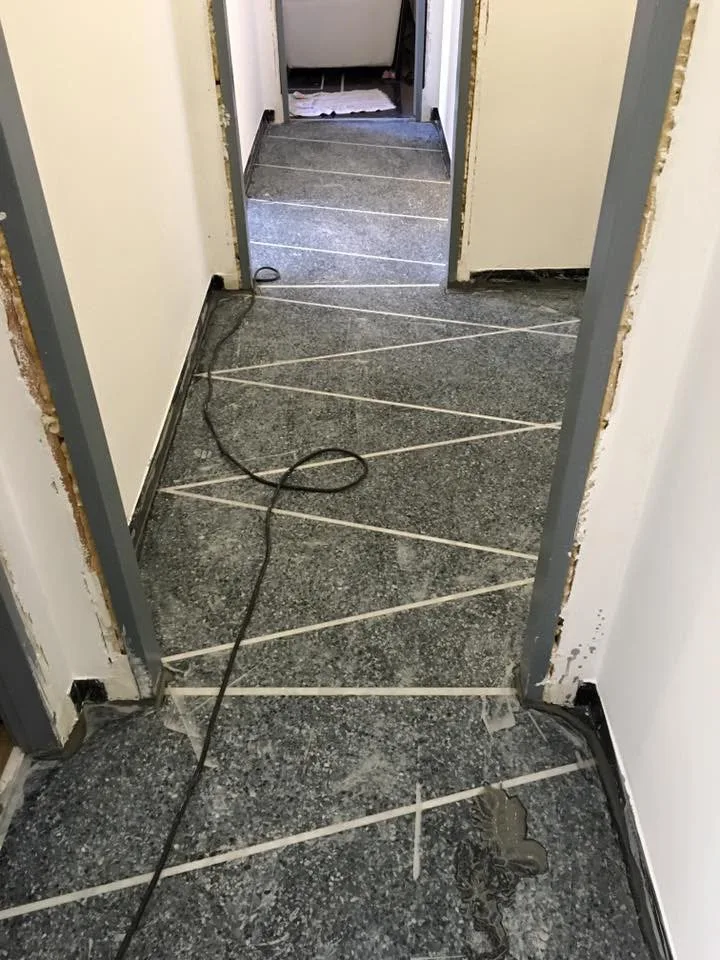Black terrazzo corridor with strip inlays before grinding and polishing