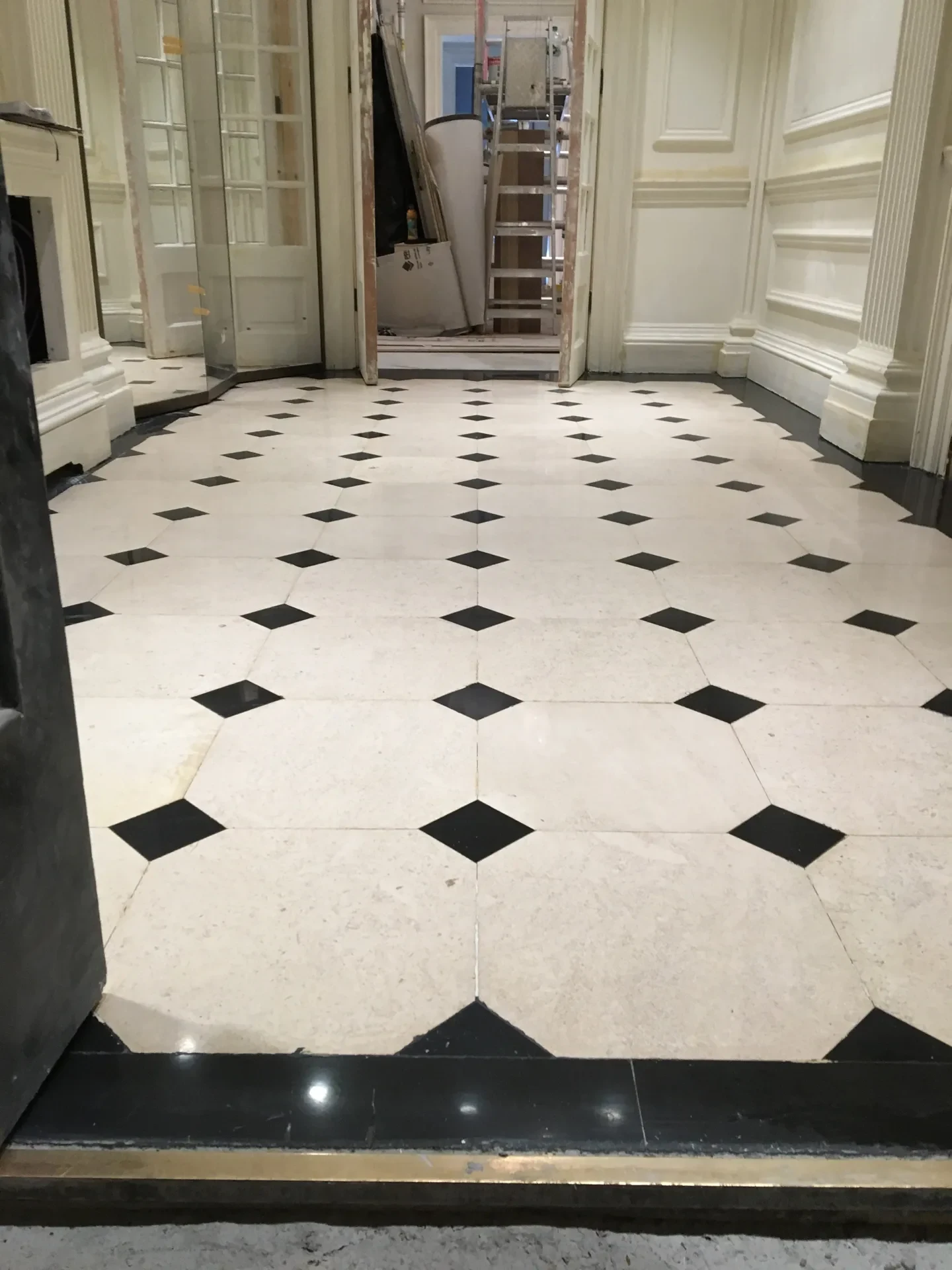 Finished cream marble hallway with polished black cabochons